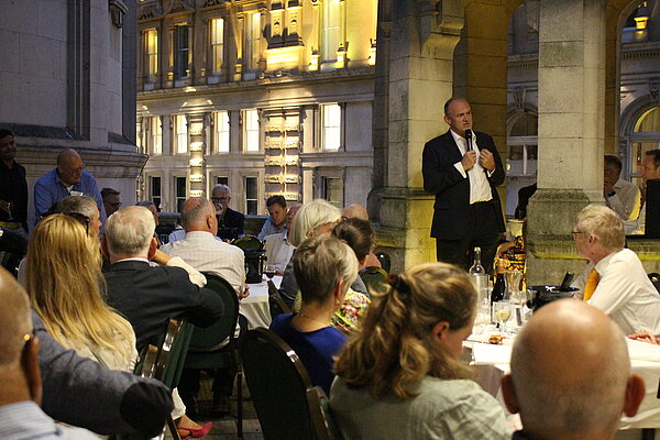 Ed Davey speaks to people seated at a dinner