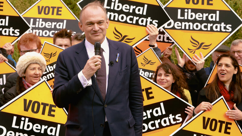 Ed Davey speaking in front of a crowd of people
